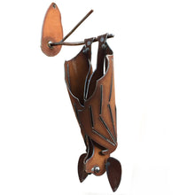 Right hanging cinnamon-rusted metal bat sculpture with closed wings