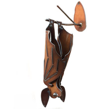 Left hanging cinnamon-rusted metal bat sculpture with closed wings
