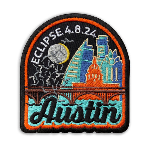 Adhesive patch featuring the eclipse plus four iconic Austin buildings, the bat bridge over water, and flying bats