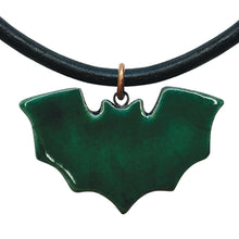 Green bat-shaped pendant on a black cord against a white background