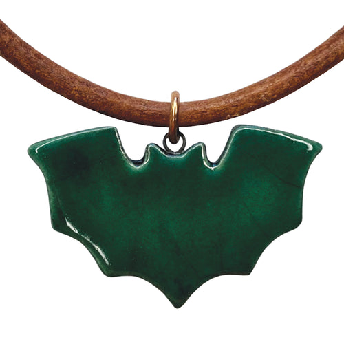 Green bat-shaped pendant on a brown cord against a white background