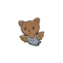 Cute baby bat cartoon pin wearing overalls with a heart stitched on the front