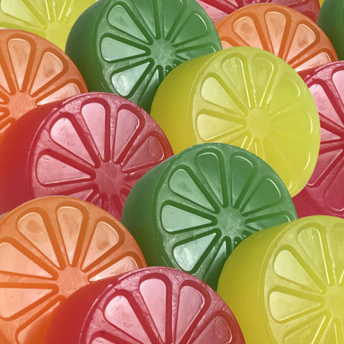 Candied citrus soap cakes stacked to display wedge detail and color