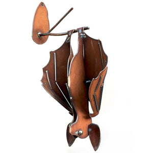 Right hanging cinnamon-rusted metal bat sculpture with open wings