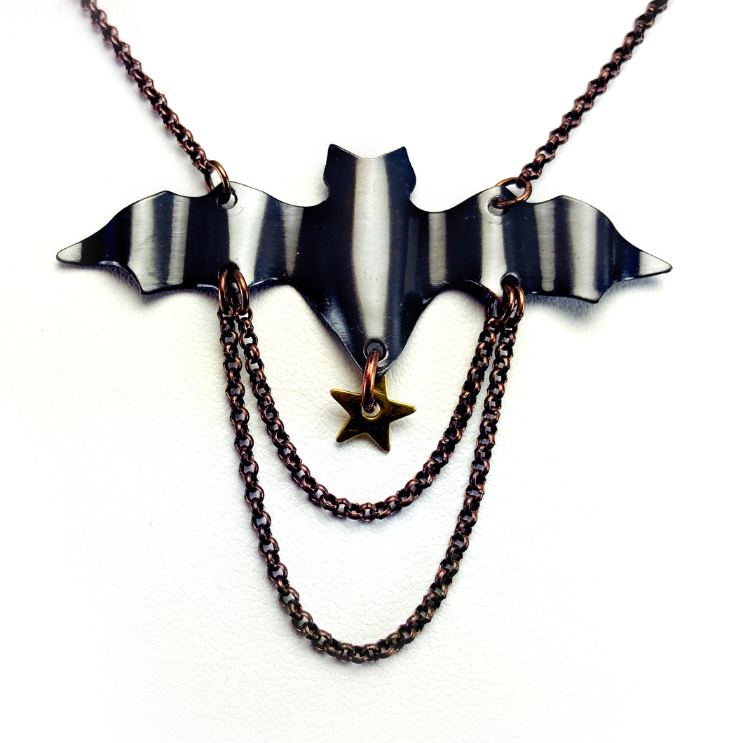 Necklace with antique copper bat hand cut and rippled, two layered chains and dangling star